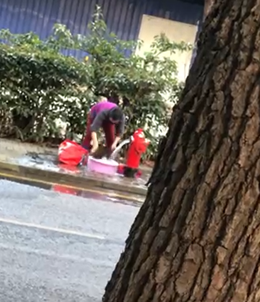 女子私开消防栓当街洗衣
